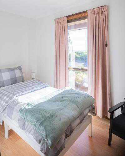 a bedroom with a bed and a window with a view at Sea Views in Devonport