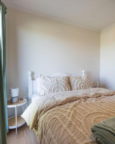 a bedroom with a bed and a white wall at Sea Views in Devonport