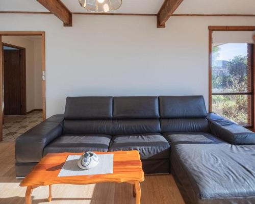 a black leather couch in a living room with a table at Sea Views in Devonport