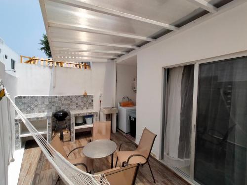 a room with a balcony with a table and chairs at CasaMEXH Veredas - Ideal para familias, vacaciones o homeoffice a10 min de la playa in Puerto Morelos