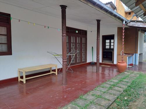 a patio with a bench and a table in a house at Shady Homestay in Matara