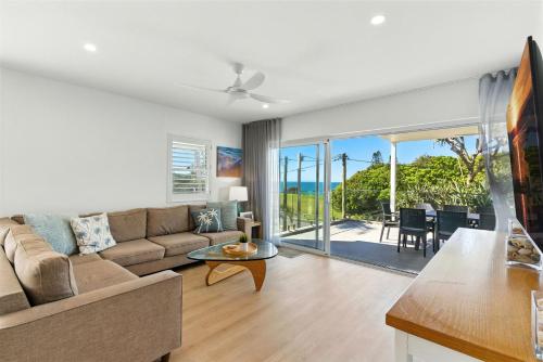 a living room with a couch and a table at Unit 2 Beach Gallery in Yaroomba
