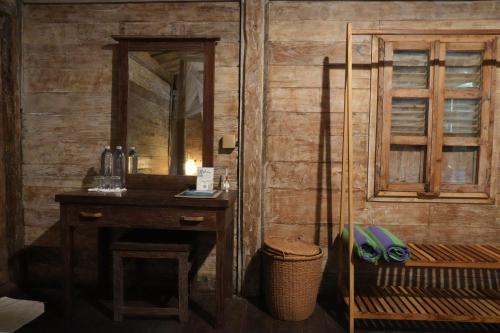 a bathroom with a mirror and a wooden wall at Nunu Bali Eco Friendly Retreat in Canggu