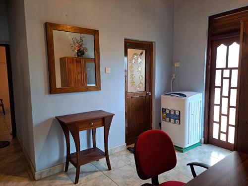 a room with a table and a chair and a mirror at Shady Homestay in Matara