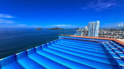 a swimming pool on top of a building next to the water at Torre Central 102: Malecón, Lujo y Vistas de ensueño. in Mazatlán
