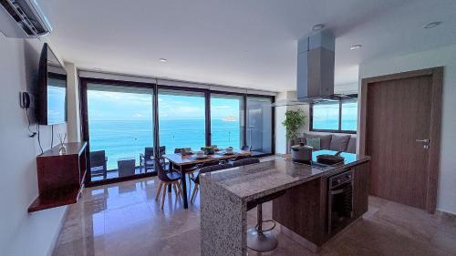 a large kitchen with a view of the ocean at Torre Central 102: Malecón, Lujo y Vistas de ensueño. in Mazatlán