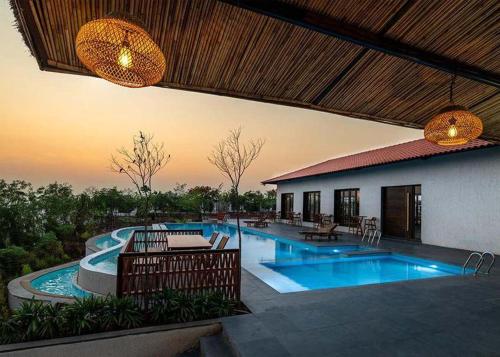 a house with a swimming pool and a patio at Manduva house in Zahirābād
