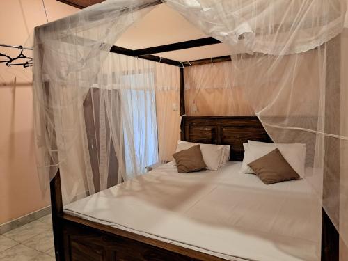 a bedroom with a canopy bed with white drapes at Shady Homestay in Matara