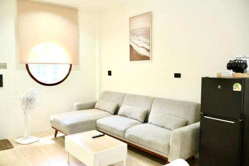 a living room with a couch and a refrigerator at Ilik House ไอลิกเฮ้าส์ in Hat Yai