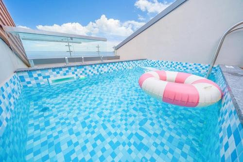 a swimming pool with a red and white float in it at The Youngjin Pool Villa Pension in Yŏngjin 2-ri