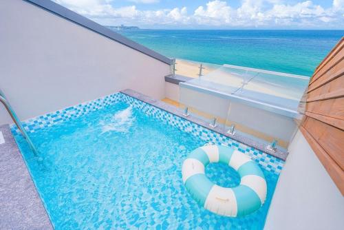 a swimming pool with a lifebuoy in front of the ocean at The Youngjin Pool Villa Pension in Yŏngjin 2-ri