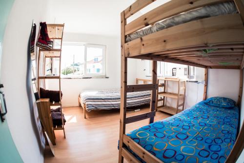 プライア・ダ・アレイア・ブランカにあるNative Surfhouseの二段ベッド2台とベッド1台が備わる客室です。