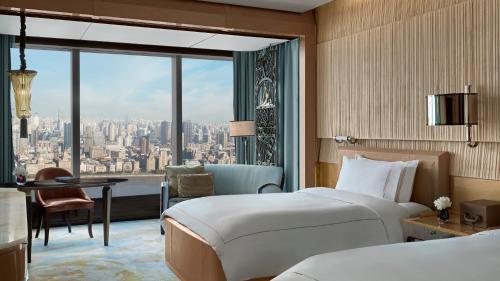 a bedroom with a bed and a view of a city at The Ritz-Carlton Shanghai, Pudong in Shanghai