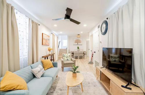 a living room with a blue couch and a flat screen tv at Mid City Canal st 2 bedroom cute house in New Orleans