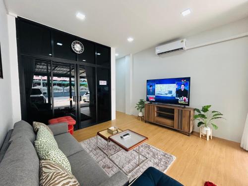 a living room with a couch and a flat screen tv at Sunsun House 10ppl 5min Nimman in Chiang Mai