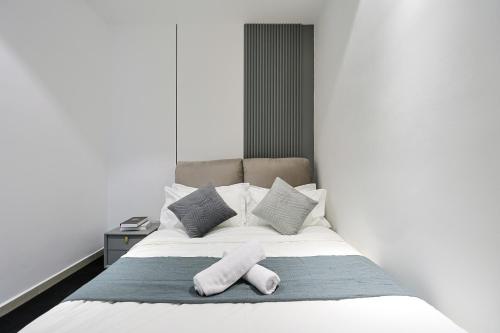 a bed with two pillows and two towels on it at Paxtonz Exsim By NexxField in Petaling Jaya