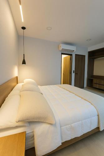 a bedroom with a large white bed with white sheets at Atrio Polanco in Mexico City