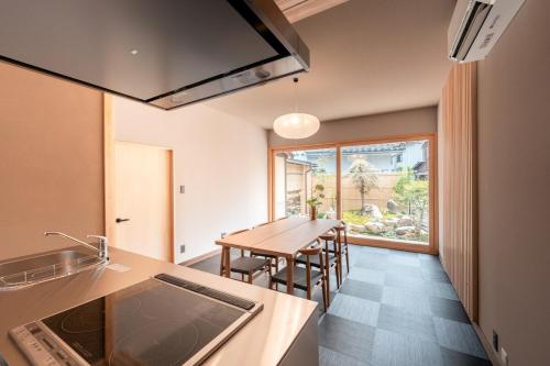 a kitchen with a table and a dining room at 飛騨高山一の響 in Wada
