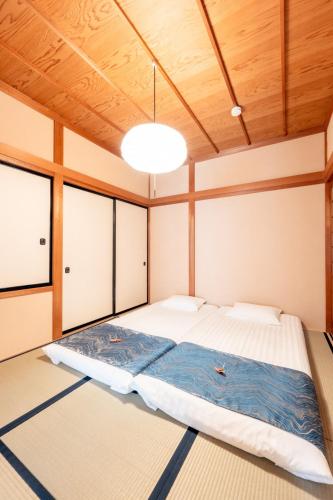 a large bed in a room with wooden ceilings at 飛騨高山一の響 in Wada