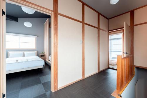 a bedroom with a white bed and a window at 飛騨高山一の響 in Wada