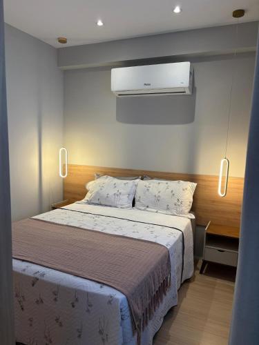 a bedroom with a large bed with a white comforter at Varanda com Vista Mar - Cristo, Bondinho e Museu! in Niterói