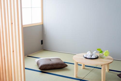 a room with a table and a dog bed on the floor at 飛騨高山一の響 in Wada