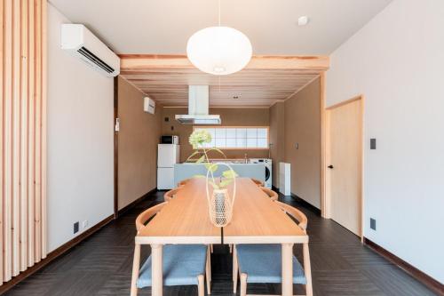 a dining room with a wooden table and chairs at 飛騨高山一の響 in Wada