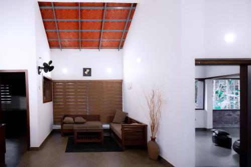 a living room with a couch and a table at Thiraa Inn Nilambur By Hotelbuz in Nilambūr