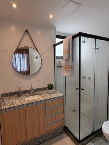 a bathroom with a shower and a sink and a mirror at Varanda com Vista Mar - Cristo, Bondinho e Museu! in Niterói