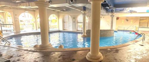 a large indoor swimming pool with columns in a building at FourSeasons Vilamoura in Quarteira