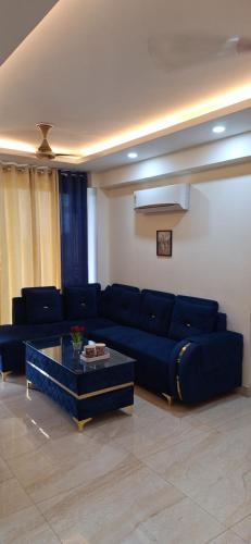 ジャランダールにある2 BHK Apartment, Jalandharの青いソファとテーブルのあるリビングルーム