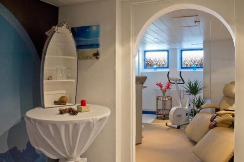 a living room with a table and a mirror at Panoramahotel Lilienstein in Königstein an der Elbe