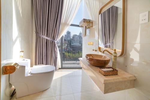 a bathroom with a sink and a toilet and a mirror at Pham Gia Dalat Villa & Hotel in Da Lat