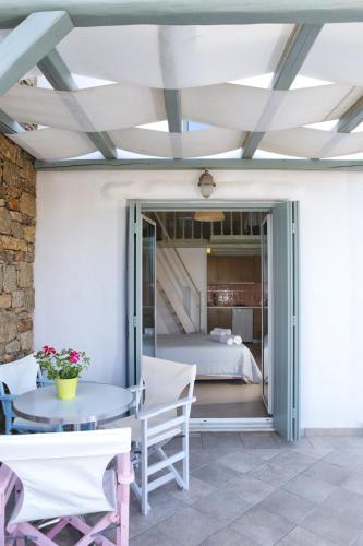 a patio with a table and chairs and a bed at Niriides Homes & Villas in Elia Beach