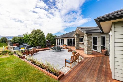 a deck with chairs and tables on a house at Relaxing Rural Retreat - Stargaze or Soak Up the Sun in Luggate