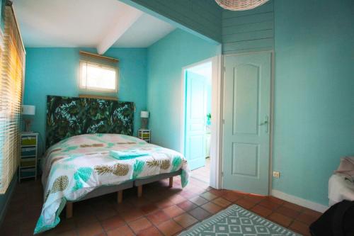 a bedroom with a bed in a room with blue walls at Gîtes La Pousterle De Sabran in Sabran