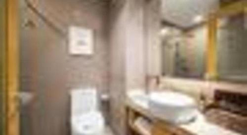 a bathroom with two sinks and a mirror at Yitel Shenyang Sanhao Street Shengjing Hospital in Shenyang