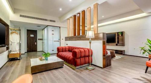 a living room with a red couch and a television at James Joyce Coffetel·Anyang Text Museum in Anyang