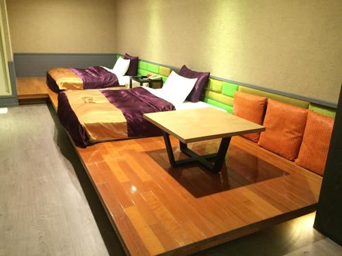 a room with two beds and a coffee table at Chusha Motel in Gongguan