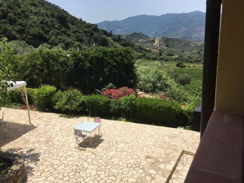 a table on a patio with a view of a mountain at Antica Tindari in Patti