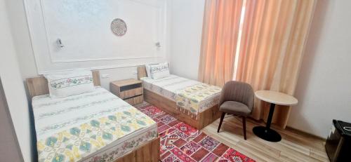 a small room with two beds and a chair at KUVONCHOY BONU B@B in Khiva