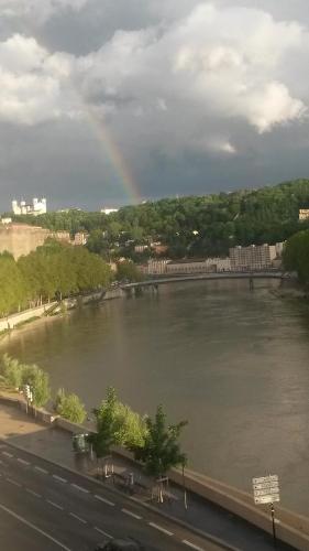 een regenboog over een rivier met een stad bij Cocon au pied de la Croix Rousse in Lyon