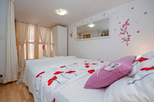 ein Schlafzimmer mit einem Bett mit roten Blumen darauf in der Unterkunft Apartment Premsai in Rovinj