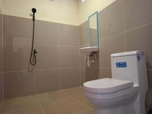 a bathroom with a toilet with a mirror and a shower at Ekas Elen Homestay in Pulau Gilkaliantan