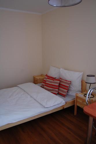 a bed with two red and white pillows on it at Przystanek Czapla in Czaplinek