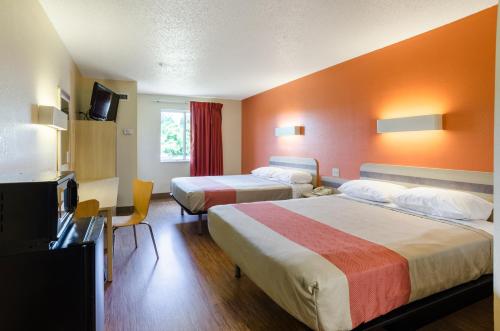 Motel 6-Bristol, VA في بريستول: غرفة فندقية بسريرين وتلفزيون بشاشة مسطحة