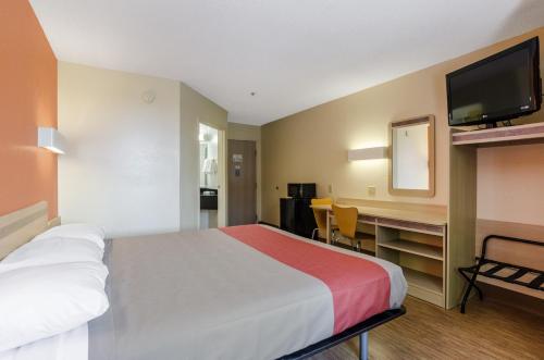 a hotel room with a bed and a desk with a television at Motel 6-Bristol, VA in Bristol