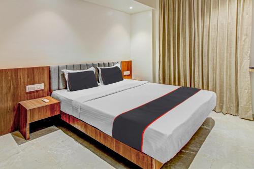 浦那Hotel O Haveli Executive的一间带大床和窗户的卧室