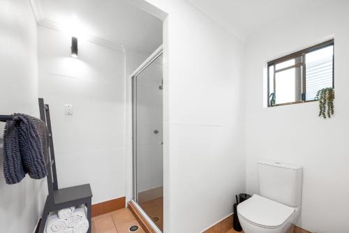 a bathroom with a toilet and a shower at Anembo Country Cottages in Eatons Hill