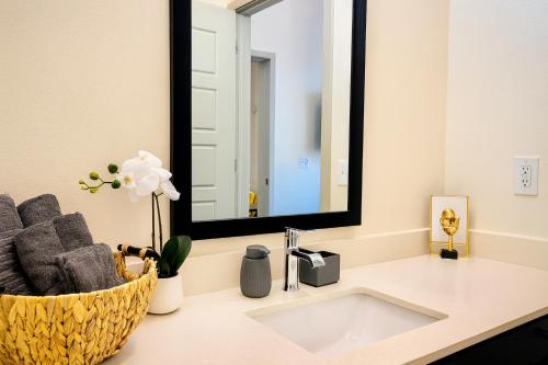 a bathroom with a sink and a mirror at Lux Modern Apartment with Pool View & Prime Location in Frisco
